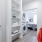 Oklahoma City, OK Affordable Apartments With In-Unit Washer And Dryer - Muse - Laundry Machines In Closet Of Bedroom Featuring Built-In Shelving And A Ceiling Fan