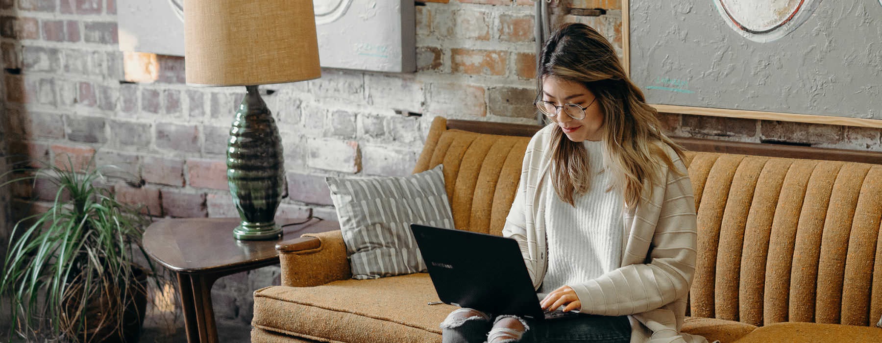 resident types on her laptop as she sits on a couch